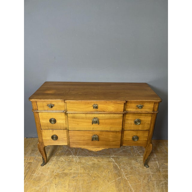 A Louis XV-Louis XVI style transitional commode in cherry wood. It rests on four cabriole legs and features five drawers...