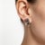 Elegant 14K white gold huggie earrings featuring a leaf design set with black and white diamonds totaling 1.8 carats....