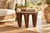 A low, oval seat of dark carved wood carries a field of incised triangles and crossed lines across its top, resting on...