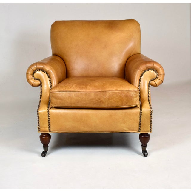 A classic leather armchair Inspired by early 1900s Edwardian furniture with elegant scooped, pleated rolled arms and brass...