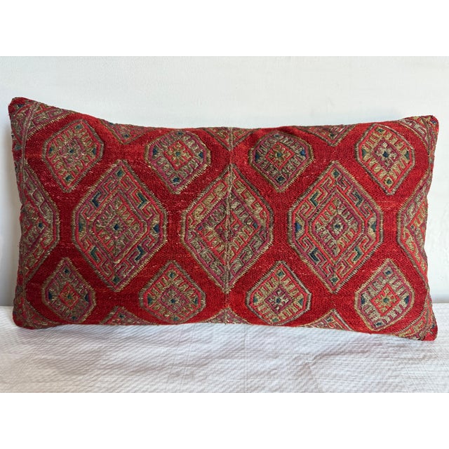This 1920 Suzani pillow features a striking combination of traditional geometric patterns and vibrant hues, adding a...