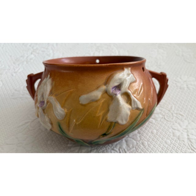 The 1939 Roseville Pottery Hanging Basket Planter in the Iris Pattern is a vintage original piece made of pottery. This...