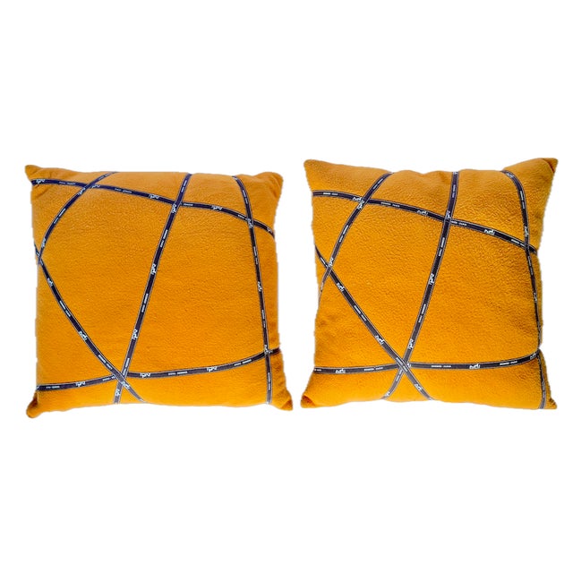 Pair of vintage orange and Hermes ribbon pillows. Orange pillows with brown ribbon with Hermes logo repeat as accent front...