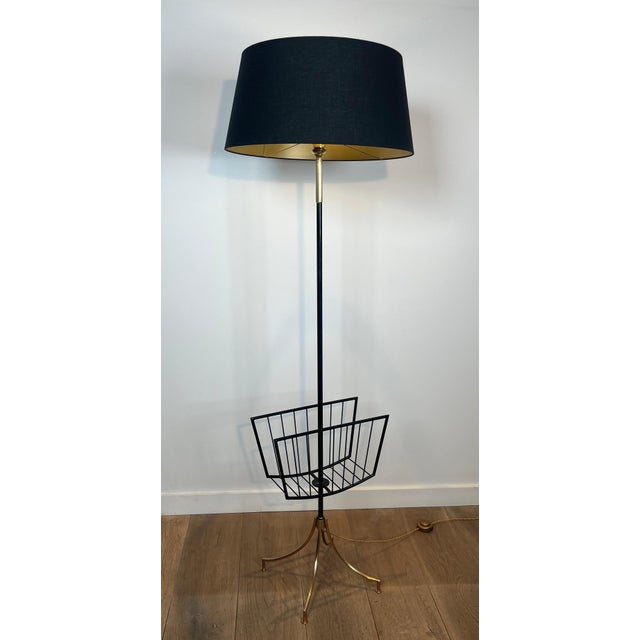 Designer floor lamp in black lacquered metal and brass with magazine rack. French work. Circa 1950