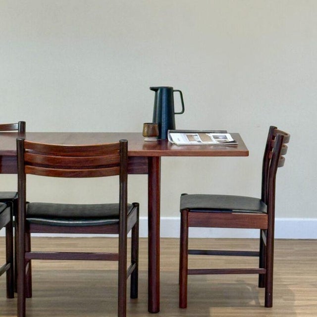 A stunning mid-century Danish dining set comprising an extending dining table and four matching chairs, designed and...