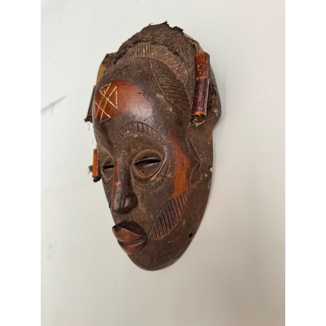 This authentic vintage African mask is a stunning hand-carved wooden piece, featuring intricate tribal detailing and...