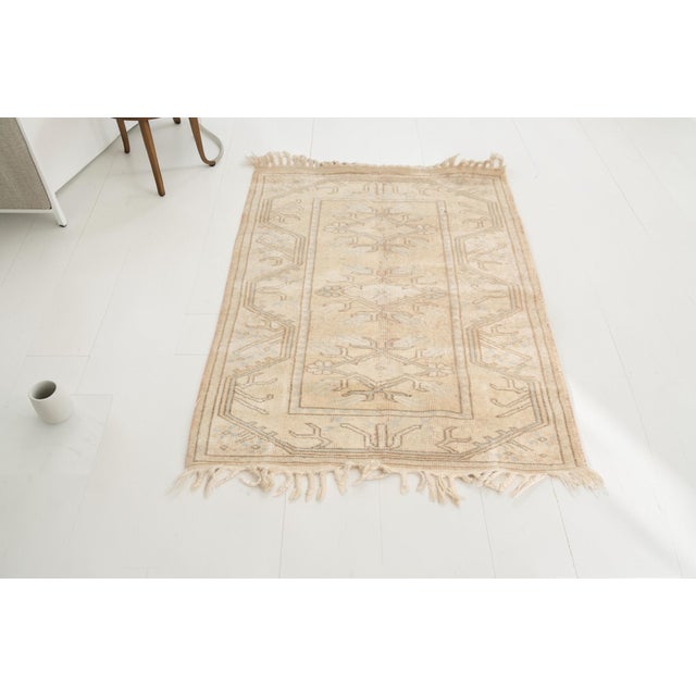 This is a vintage Turkish Oushak rug from the Mid 20th Century. The piece was hand-knotted.