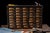 This folk art cabinet was made by hand and features forty drawers made from gold colored tin that measure 4.25" in width,...
