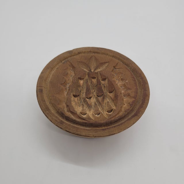 Antique hand-carved wooden butter mold featuring a classic pineapple motif, a traditional symbol of hospitality. This...