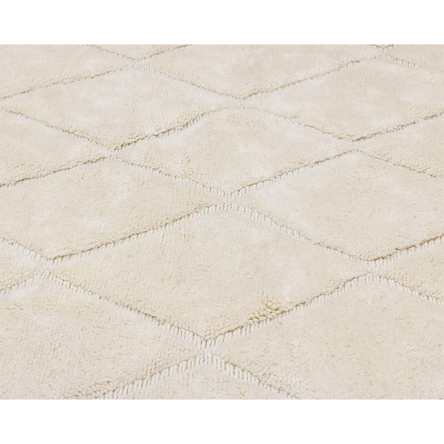 Elegant hand-knotted Ivory rug showcasing a delicate diamond pattern, offering a soft, luxurious texture that complements...