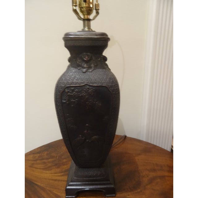 A beautiful bronze finished lamp with Classical Chinese scenes and a wood base. Fine Quality.