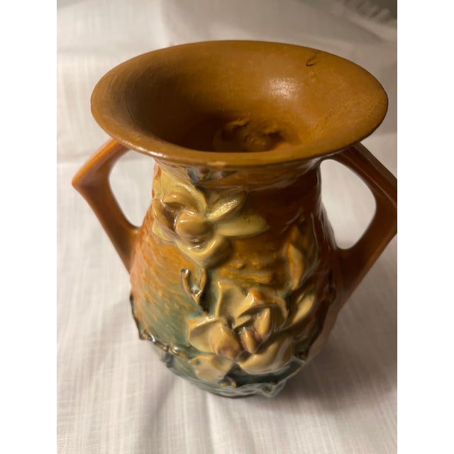 This vintage Roseville Magnolia 90-7 Vase is a stunning art deco piece featuring a beautiful brown and gold raised floral...