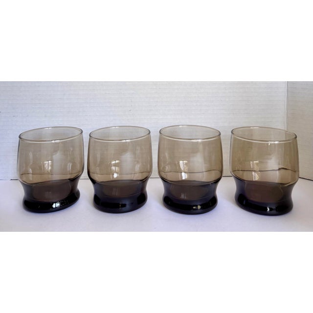 These vintage smoky brown lowball rocks glasses feature a clean, sculptural silhouette that feels distinctly Mid-Century...