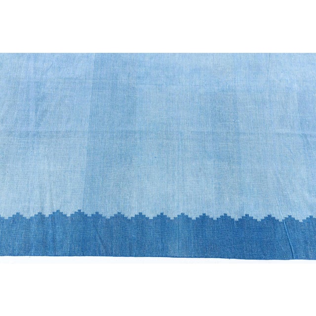 This vintage 1955 Indian Dhurrie rug embodies the essence of mid-century modern minimalism, where simplicity and subtle...