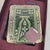 Presented in its original Michael Hero box, this ornate jeweled picture frame features green enamel-style detailing, gold-...