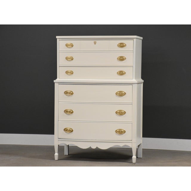 A painted white tall dresser with brass color drawer pulls. Minor indentations and wear on paint with age and use. Circa...