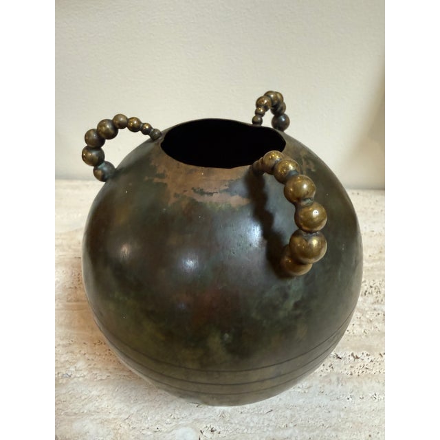 Striking Italian brass vase from the 1970s, defined by its bold spherical silhouette and richly developed patina. The...