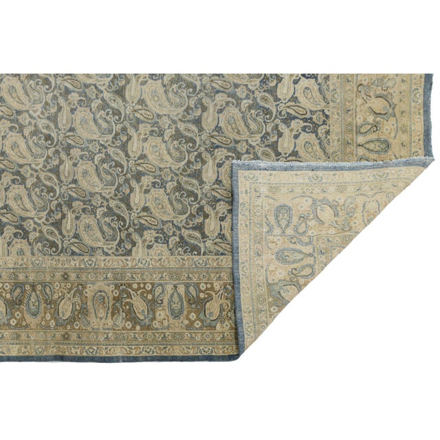 This exquisite antique Tabriz wool rug features a rare, finely woven allover paisley (boteh) design set against a deep...