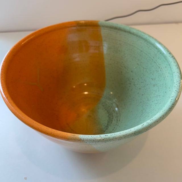 Handmade by BOKA Pottery, this ceramic pottery bowl features a distinct split colorway design with orange and mint green...