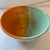 Handmade by BOKA Pottery, this ceramic pottery bowl features a distinct split colorway design with orange and mint green...