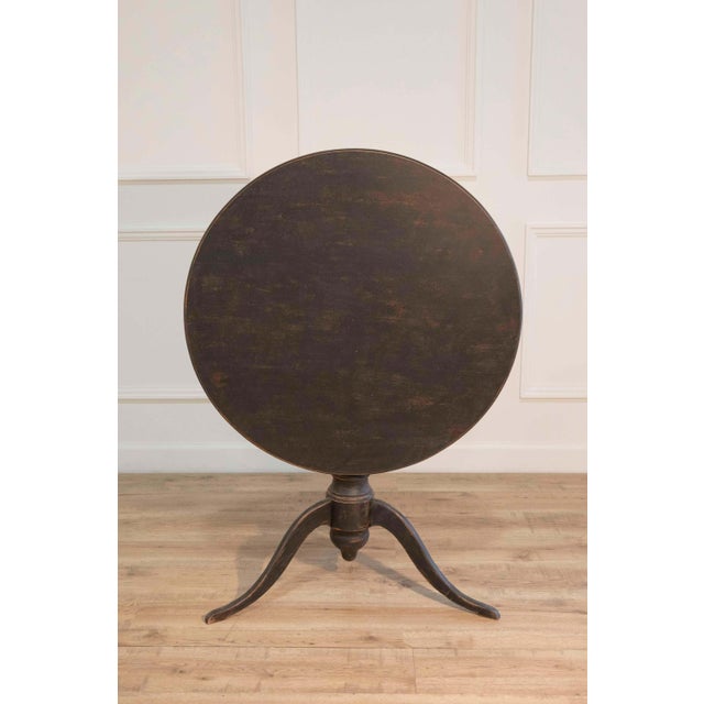 A refined 19th-century Swedish tilt-top table embodying the restrained elegance of the Gustavian period. The circular top...
