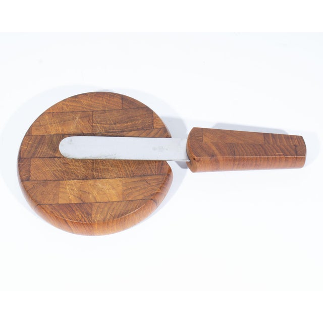 A teak cheese board with a knife by the Danish designer Jens Quistgaard (1919-2008) for Dansk International Designs....