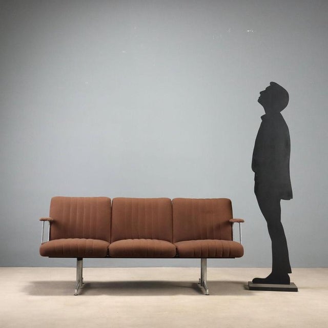 Vintage three-seater sofa featuring a minimalist design. The clean lines make it suitable for various settings, from a...
