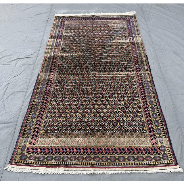 A vintage Baluch tribal rug in the collectible Mina Khani ("thousand flowers") design — an all-over rosette trellis of...