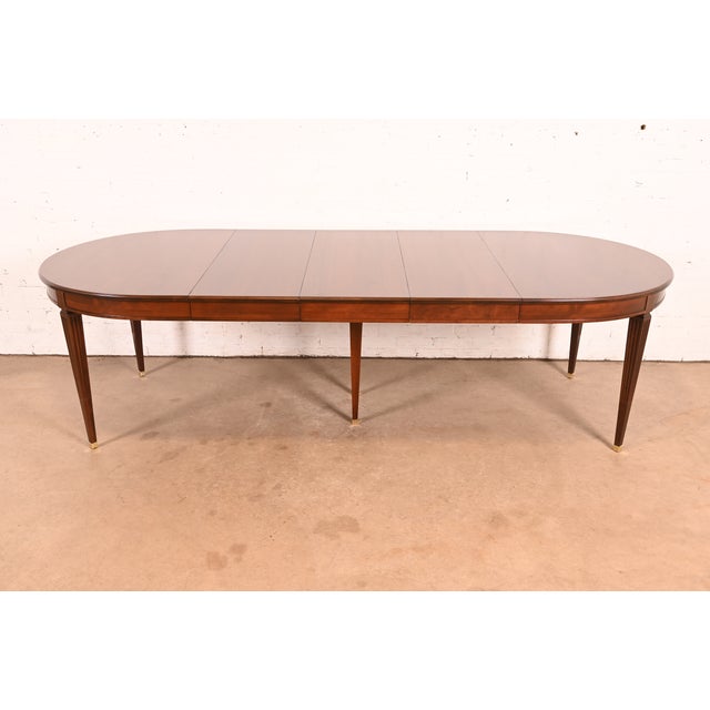 An exceptional French Regency Louis XVI style extension dining table By Kindel Furniture USA, Circa 1980s Gorgeous carved...