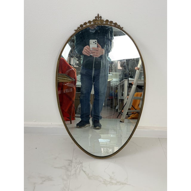 Oval wall mirror with brass edge in the style of Gio Ponti, 1950s Strains of age on the mirror. The brass edge has not...