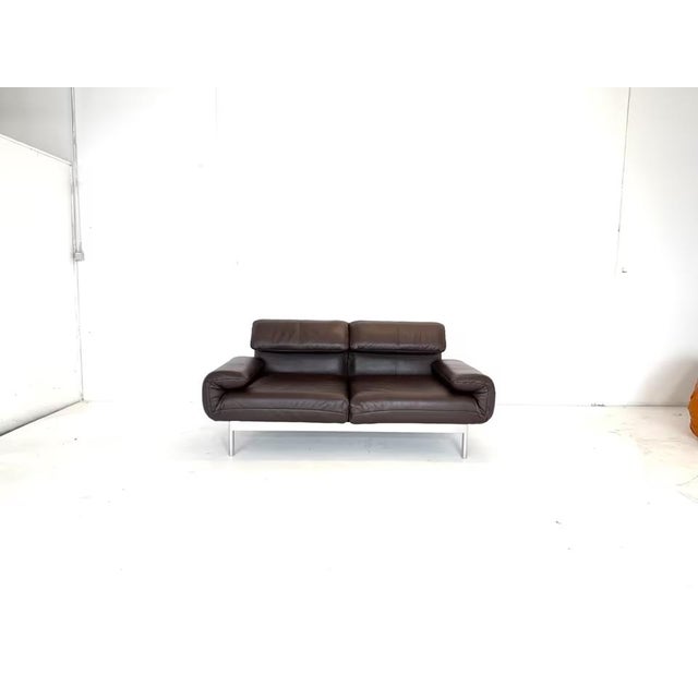 Manufacturer: Rolf Benz Color: Brown leather Frame: Chrome-plated Model: Plura Dimensions: Width 186–262 cm, Height 82–108...