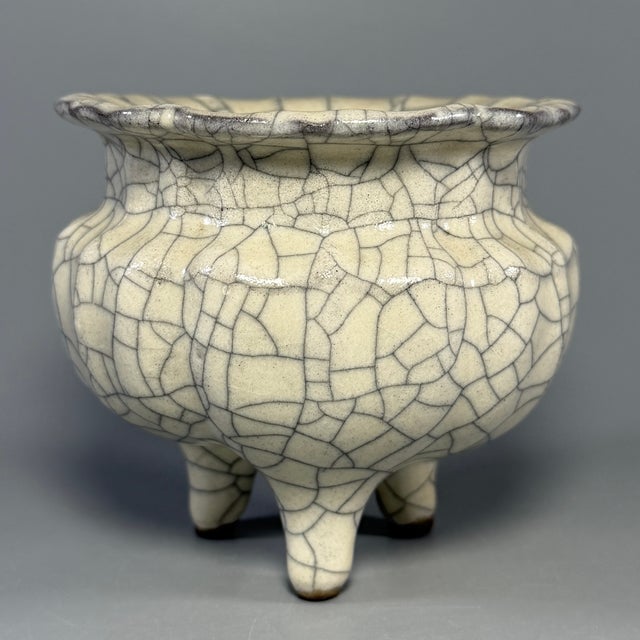 This vintage‑style Chinese tripod censer is covered with beautiful natural crackle‑glaze finish. It owns scalloped rim,...