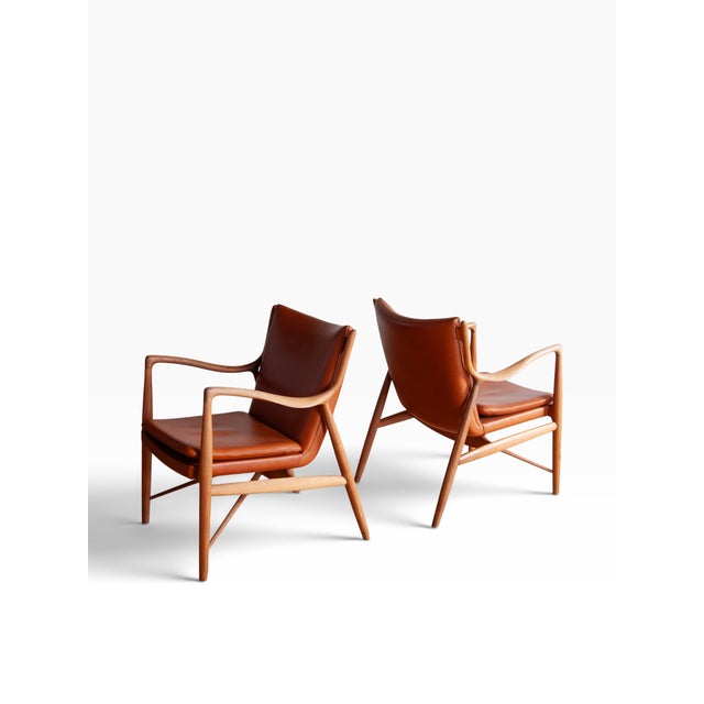 We are pleased to present a pair of iconic Finn Juhl 45 Chairs. These 2000s edition chairs are signed by House of Finn...