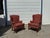 A handsome pair of Chippendale-style fireside wingback chairs featuring classic high backs, sculpted wings, rolled arms,...