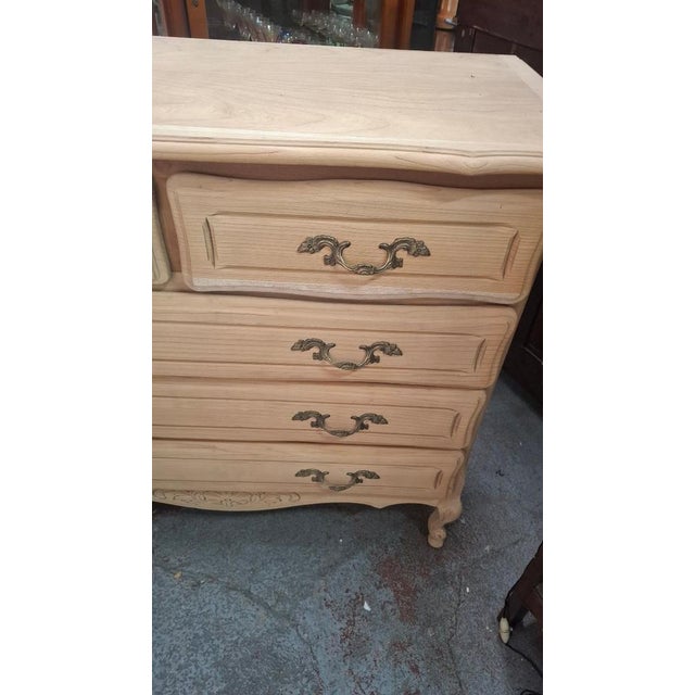 A Louis XV style cherrywood chest of drawers that has been stripped. This chest has three rows of drawers, including two...