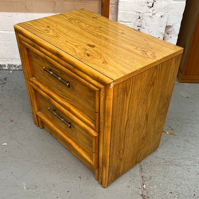 Vintage Hollywood Regency style nightstand by Lea Furniture features a durable oak laminate finish with molded faux bamboo...