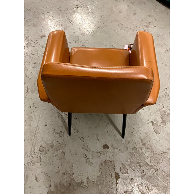 armchair designed in 1960s Italy. Structure in black lacquered metal and upholstered in original tan leather