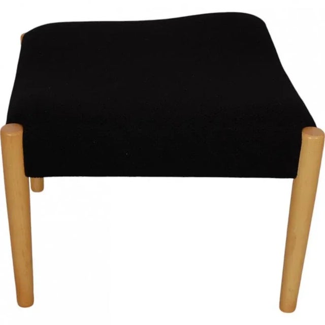 Nanna Ditzel Circle stool upholstered in black fabric and with legs of beech. The stool is from 2015 and appears in good...