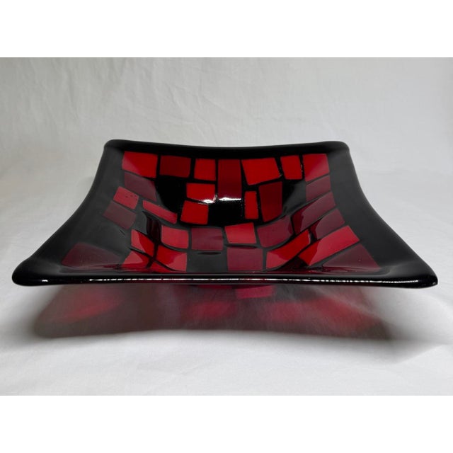 Mid century fused glass bowl with geometric pattern of squares and rectangles in shades of red with black border. A small...