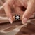 Bold and captivating, this flower-halo ring pairs striking midnight-black outer gems with a brilliant clear center,...