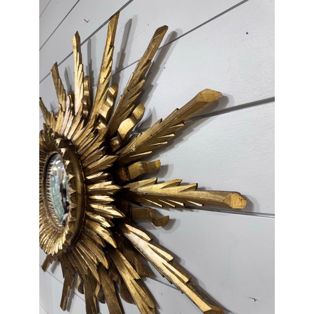 This is a gorgeous gilt wood convex mirror! Done in layered sunburst style, there are three layers of rays made up of...