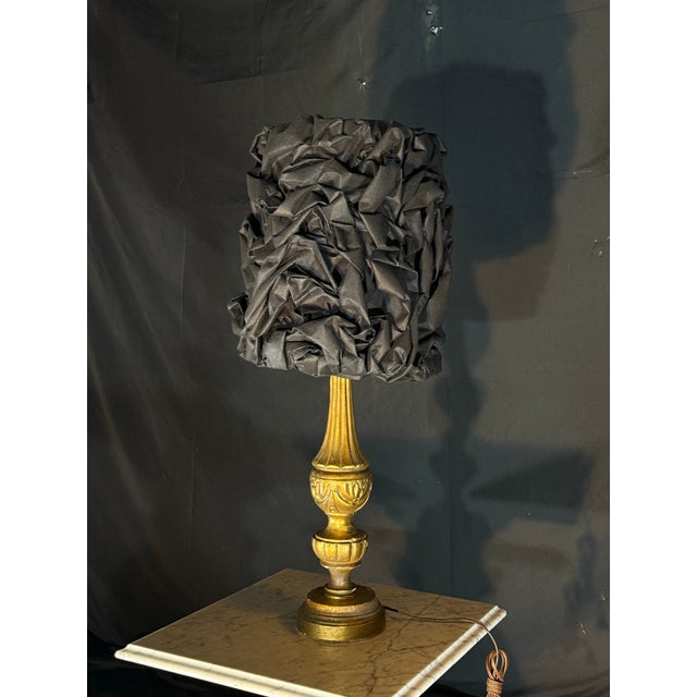 One-of-a-kind table lamp featuring an ornate antique gold-tone base with a dramatic black sculptural textured shade. The...