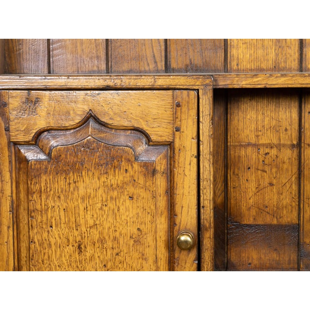 An English oak dresser from the mid 20th century, with dentil molding, carved cornice, open shelves, six doors and six...
