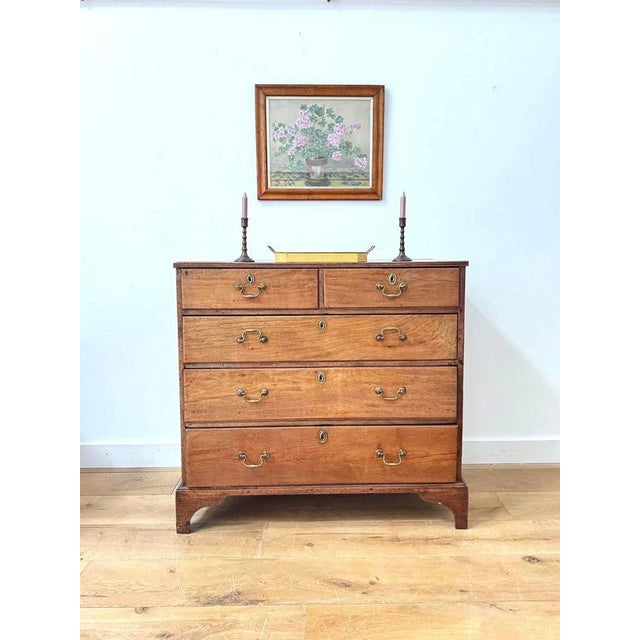 A stunning 18th century varnished fruitwood set of drawers, in a two over three drawer arrangement, with traditional brass...