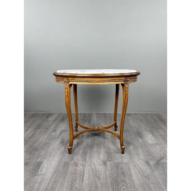An elegant oval pedestal table in carved wood, dating from the late 19th century and crafted in the Louis XVI style. The...