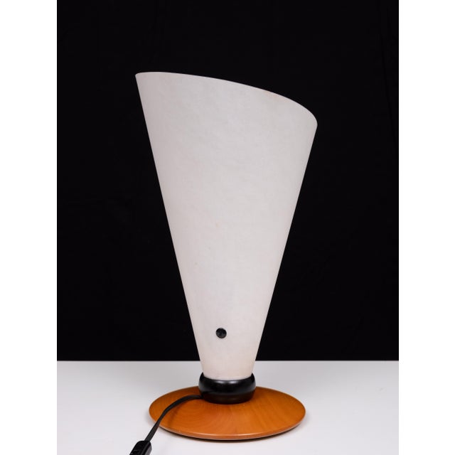 The warm Lunopal flare emphasizes the fine wooden lamp foot. The rolling shade is brought into form by two buttons and...