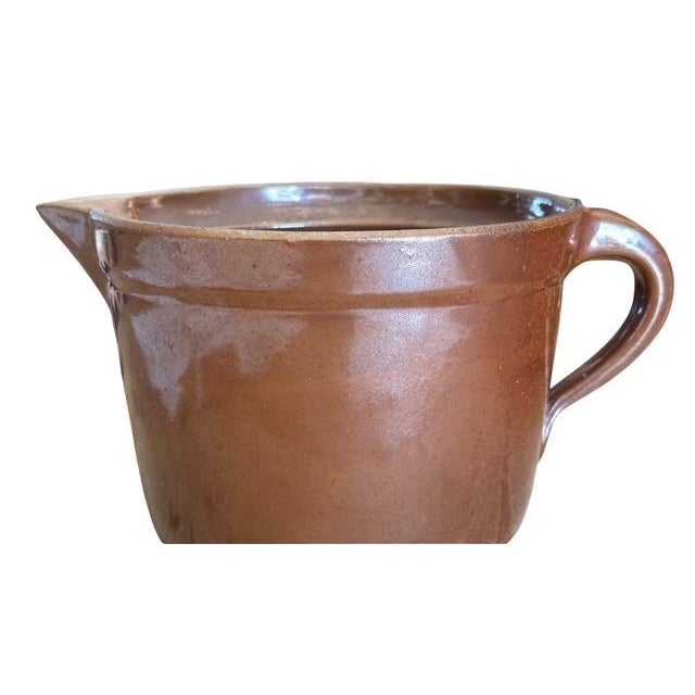 A 1910s German stoneware pitcher with handle and spout — rustic farmhouse charm. Measures 9"W x 7"D x 5"H. A wonderful...