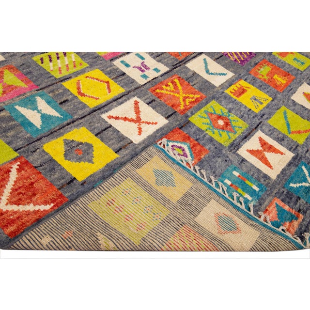 Beautiful Moroccan style handmade wool rug with a blue field. This Modern rug has multicolor accents and beige fringes...