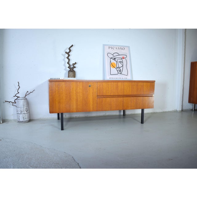 This is a beautifully designed vintage sideboard from the 1960s. The design is characterized by clean, minimalist lines....