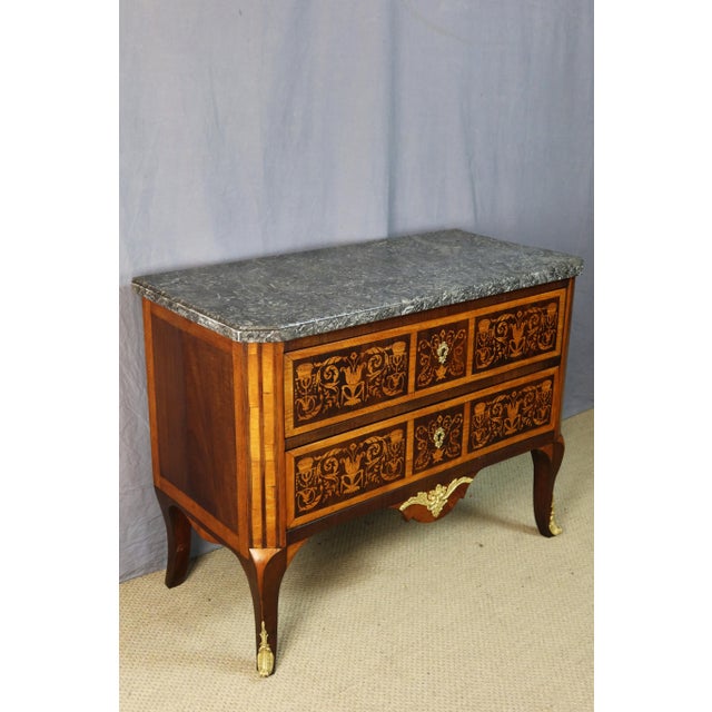 18th-century marquetry commode from the Transition period. This commode opens with two drawers and rests on four slightly...